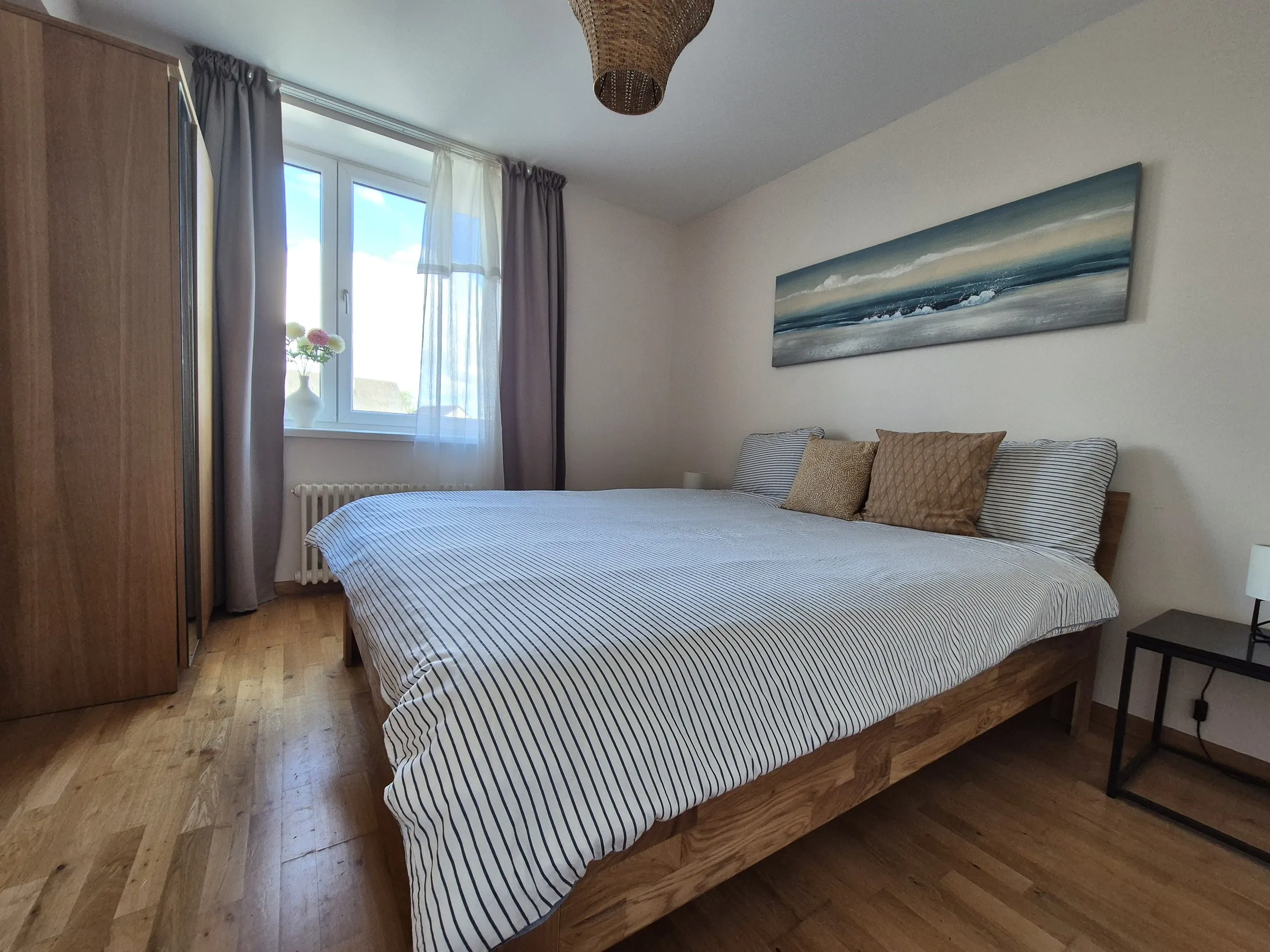 Bedroom with a double bed and a painting of the sea