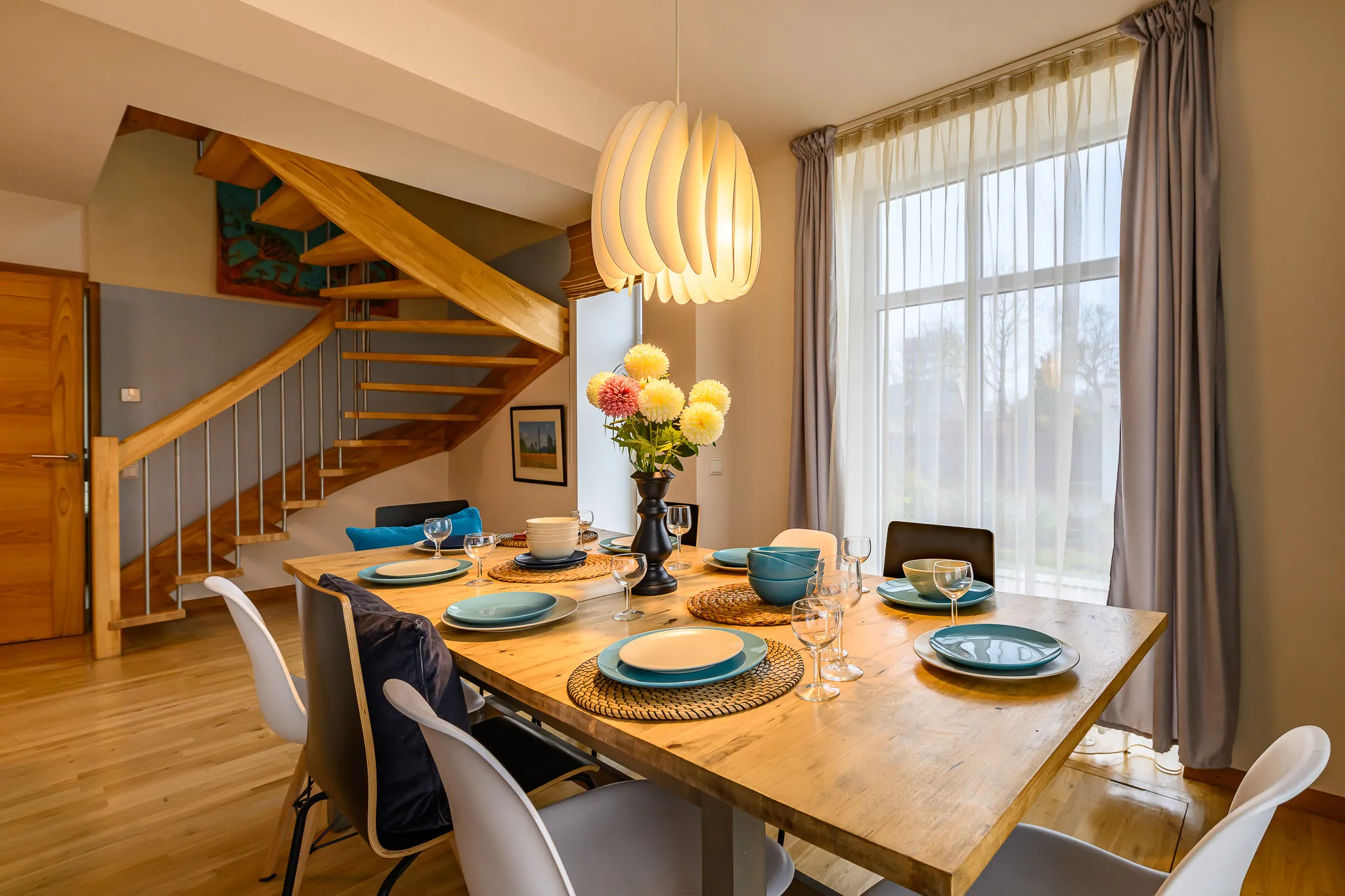 Dining table set for eight, with the oak staircase behind