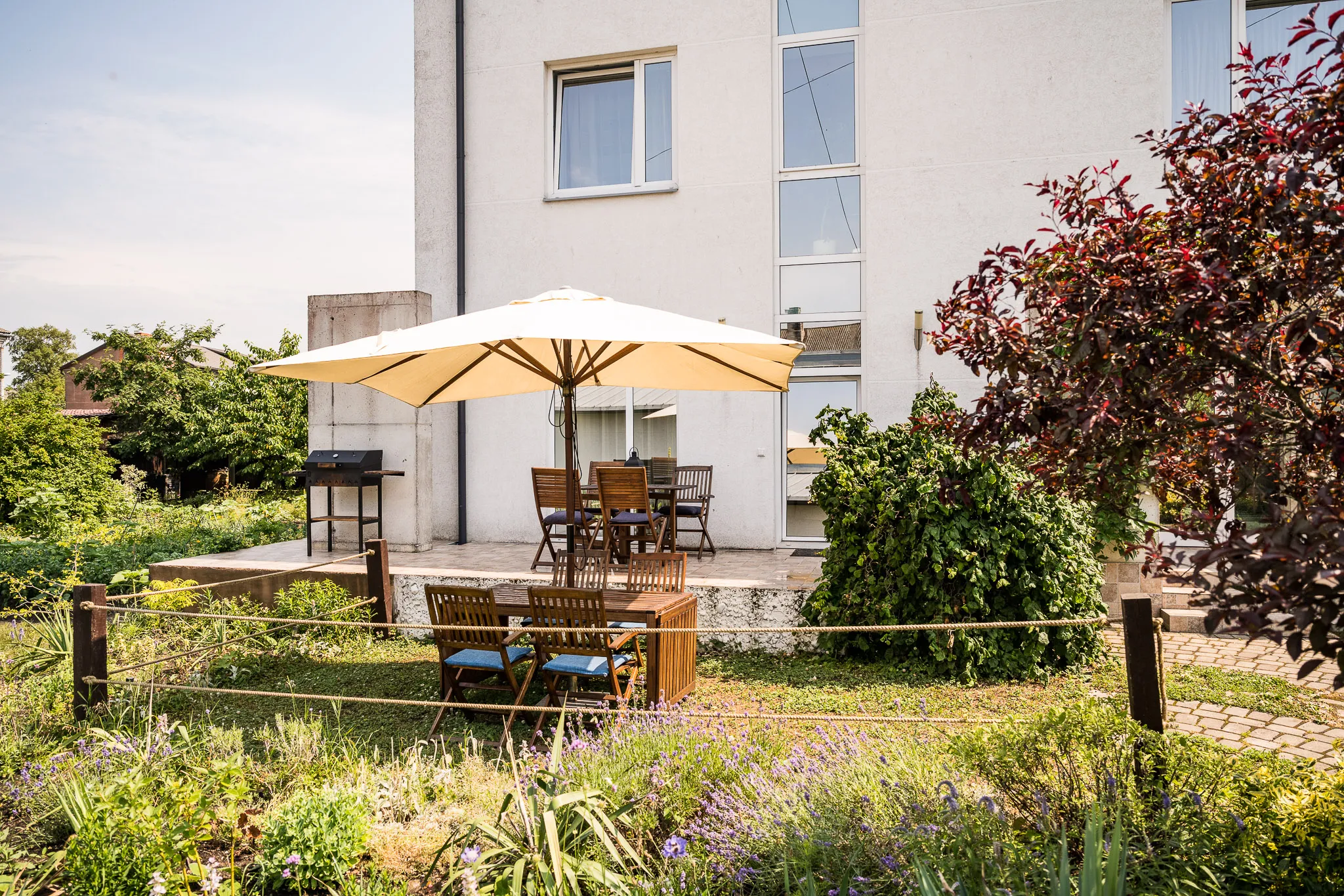 Terrace with a barbecue, a parasol and garden seating